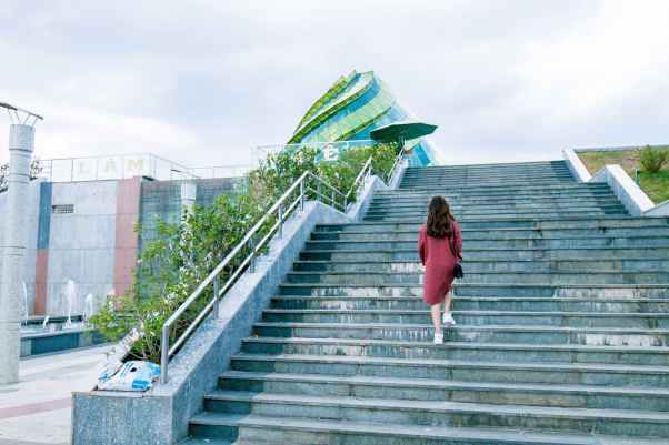 woman wearing red dress on gray stairs